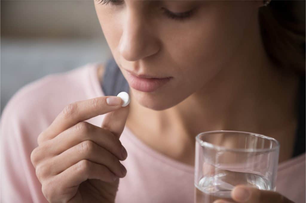 woman taking pill for toothache