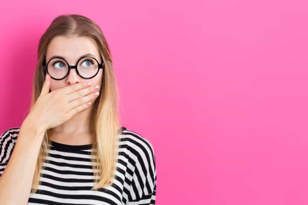 The lady is covering her mouth when she senses tooth pain.